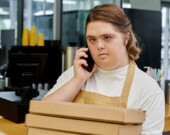 Young woman with Down Syndrome working in a cafe. | Photo by Lightfield Studios.  