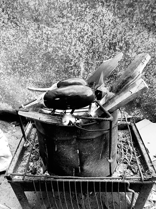 Cooking on a makeshift stove, photo from Pizza Before We Die (Arsenal Pulp Press, 2026). | Photo by Hassan Kanafani.    