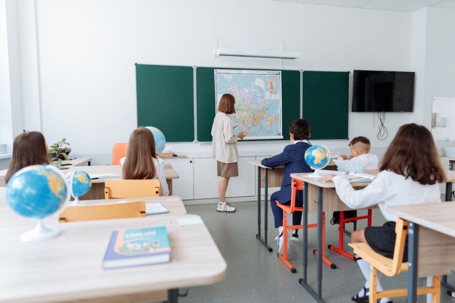 Une enseignante accompagne des élèves en classe | Pexels  