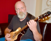 Jacques Mimeault de La Martre explore une nouvelle façon de jouer de la guitare, qu'il présente comme modale ou dulcimer. Photo : Johanne Fournier.  