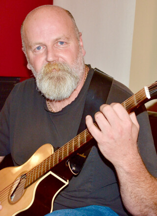Jacques Mimeault de La Martre explore une nouvelle façon de jouer de la guitare, qu'il présente comme modale ou dulcimer. Photo : Johanne Fournier.  